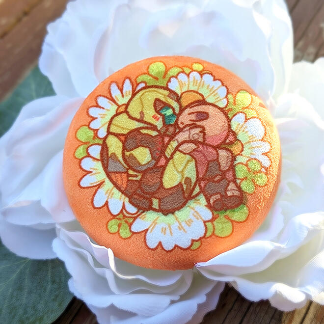 Soft plush fabric on a metal pin backing. Design based on DOOM Eternal.